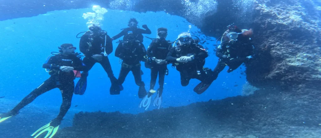 Buceadores explorando el Arco en Formentera en aguas claras y abiertas