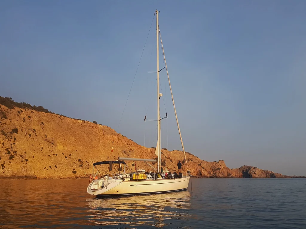 Buceo en Tagomago Norte con barco fondeado junto a la costa rocosa antes de la inmersión
